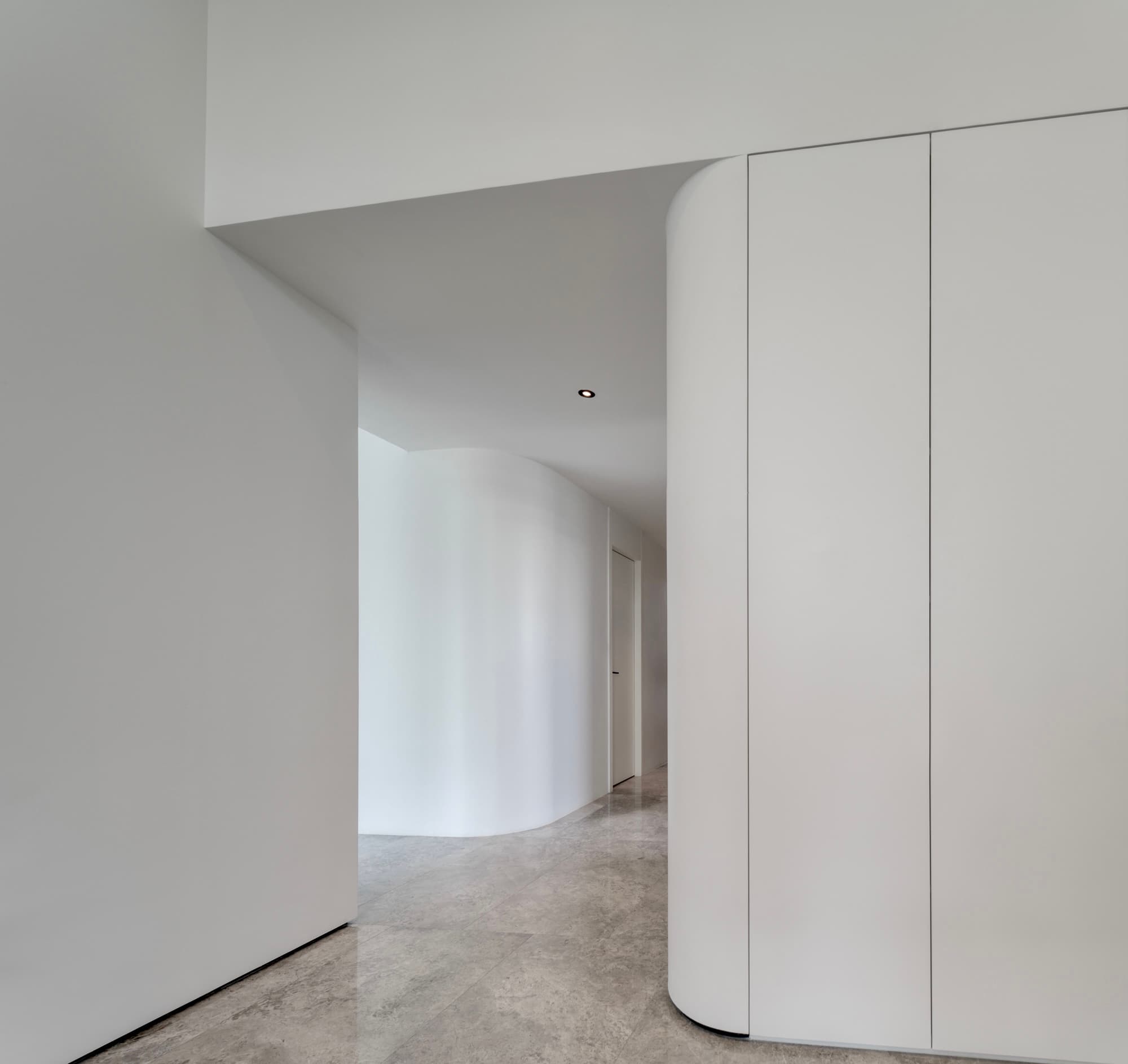 L2 interior — curved white volume and marble floor